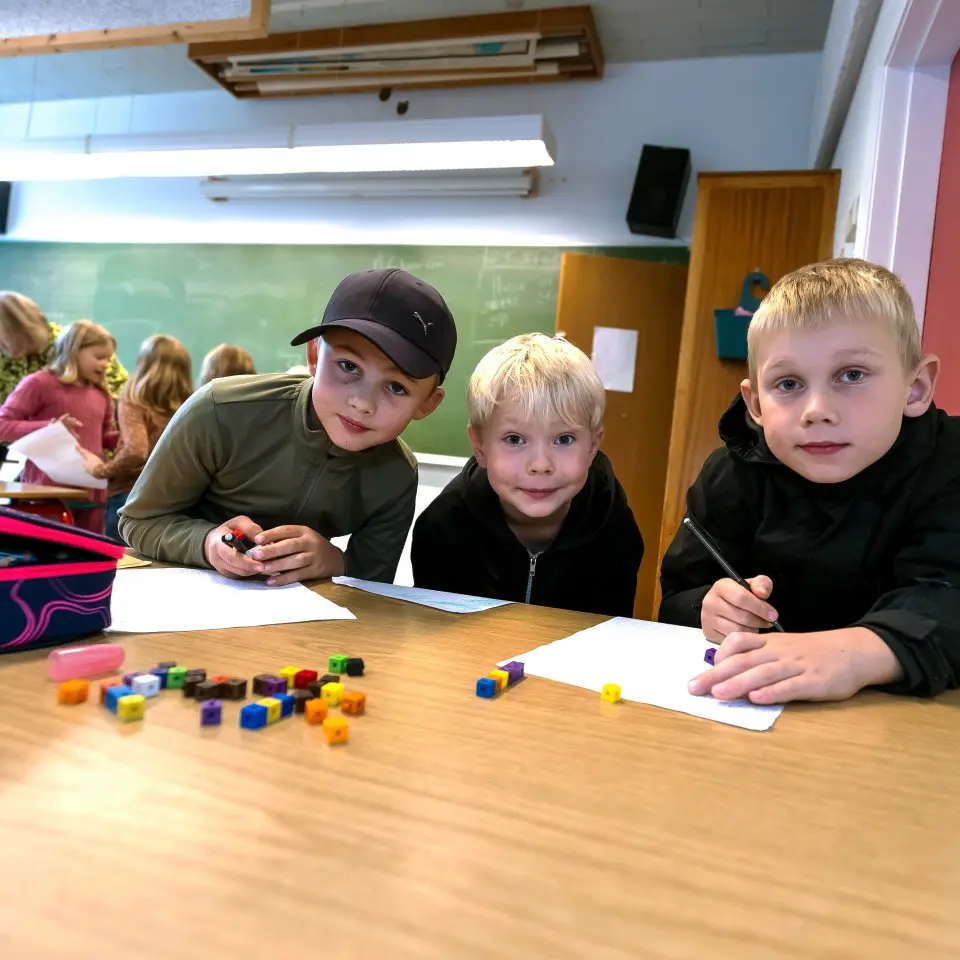 Elever i forskellige aldre arbejder sammen med klodser ved et bord